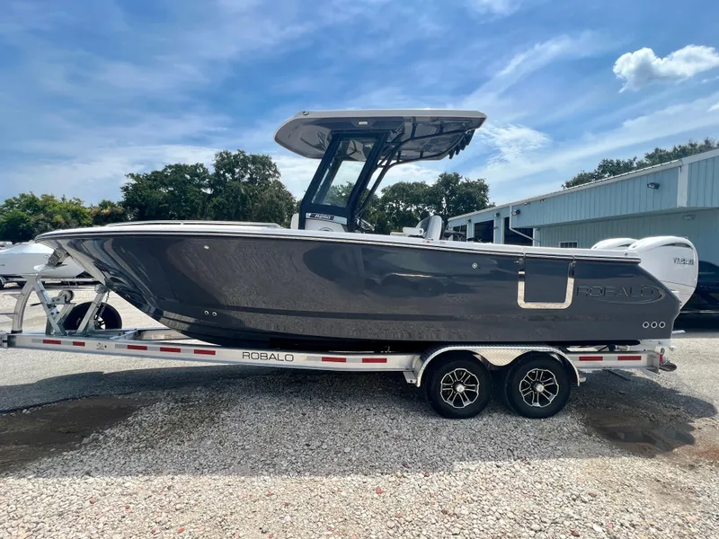 Slide: The Image of 2025 Robalo R250 boat on a trailer under a clear blue sky. - 4