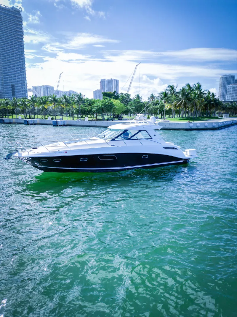 The Image of 2010 Sea Ray 450 Sundancer yacht cruising in a tropical marina. - 0