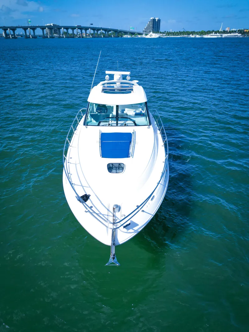Slide: The Image of 2010 Sea Ray 450 Sundancer yacht cruising on blue water near a bridge. - 4