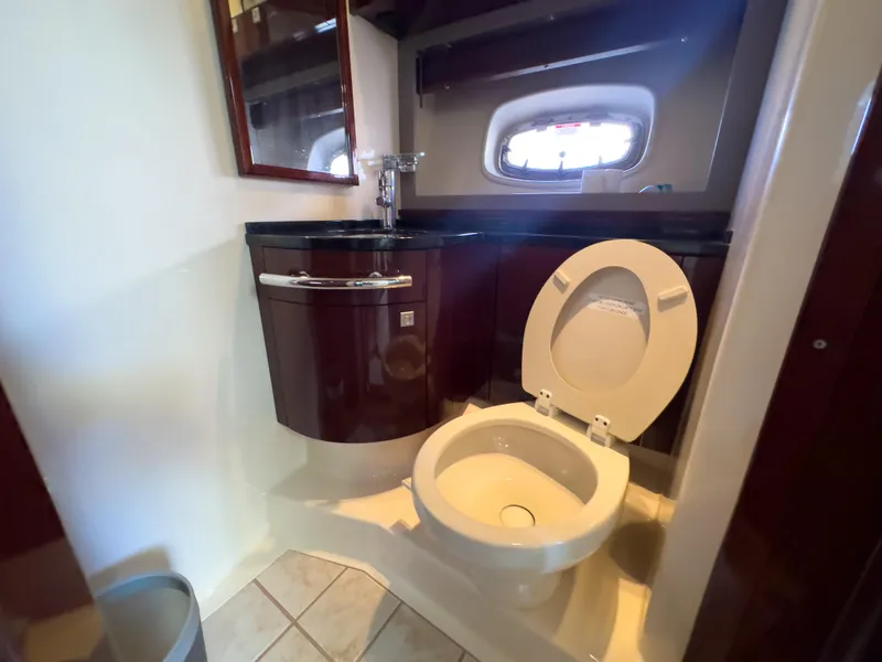 Slide: The Image of 2010 Sea Ray 450 Sundancer bathroom with toilet, sink, and mirror. - 8