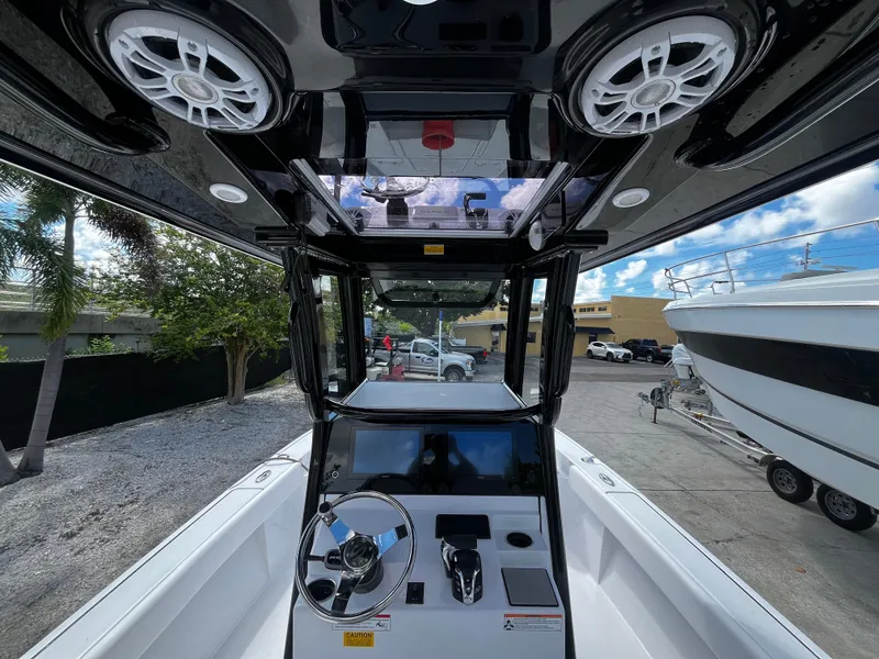 Slide: The Image of 2024 Sportsman Masters 267 Bay Boat cockpit with steering wheel and control panel. - 18