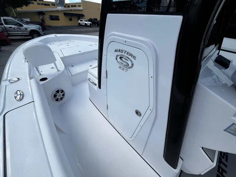 Slide: The Image of 2024 Sportsman Masters 267 Bay Boat, white deck and console, docked in marina. - 27