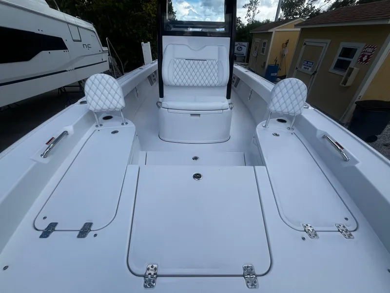 Slide: The Image of 2024 Sportsman Masters 267 Bay Boat interior with white seating and storage compartments. - 30