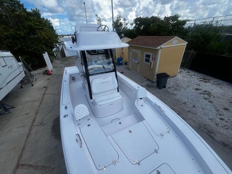 Slide: The Image of 2024 Sportsman Masters 267 Bay Boat docked near a yellow shed. - 32