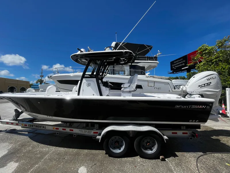 Slide: The Image of 2024 Sportsman Masters 267 Bay Boat on a trailer under a clear blue sky. - 6