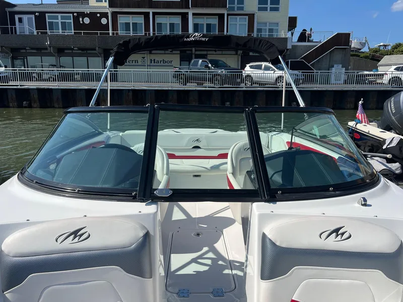 Slide: The Image of 2015 Monterey 204FS boat docked at a marina with a black bimini top. - 11