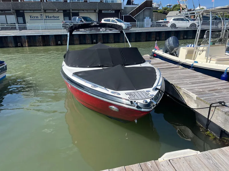 Slide: The Image of 2015 Monterey 204FS boat docked at marina with black cover. - 3