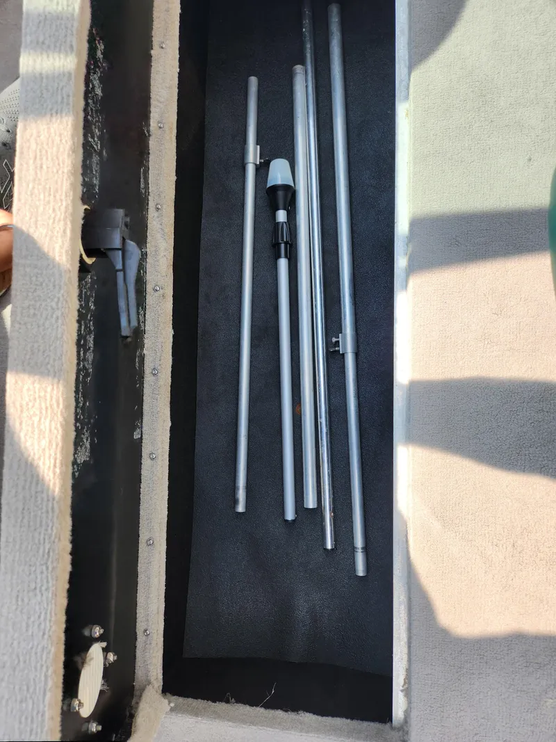 Slide: The Image of Storage compartment with metal poles in a 2000 Crownline 192 BR boat. - 12