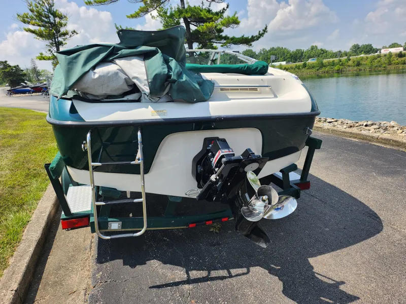 Slide: The Image of 2000 Crownline 192 BR boat parked near a lake, rear view. - 2