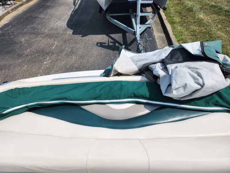 Slide: The Image of 2000 Crownline 192 BR boat with green and white upholstery, partially covered. - 21