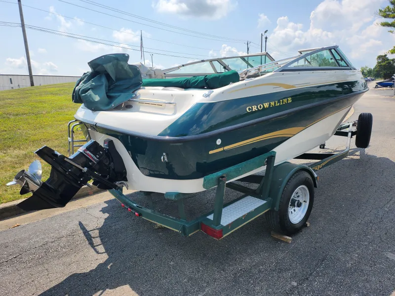Slide: The Image of 2000 Crownline 192 BR boat on trailer, green and white, outdoor setting. - 3