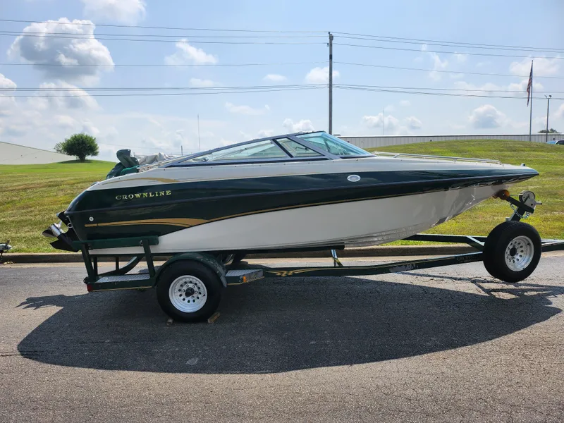Slide: The Image of 2000 Crownline 192 BR boat on a trailer under a sunny sky. - 4