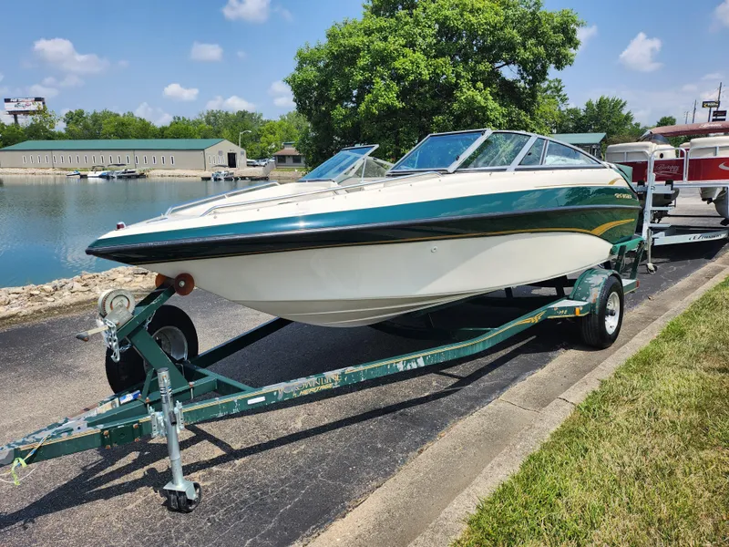 Slide: The Image of 2000 Crownline 192 BR boat on trailer by a lake. - 8