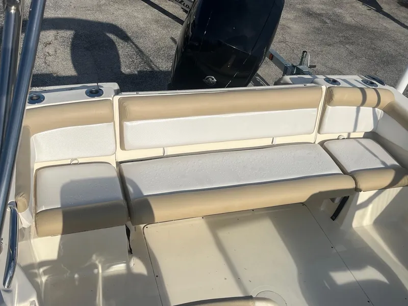 Slide: The Image of 2021 Scout 210 Dorado boat interior seating area with beige and white cushions. - 3