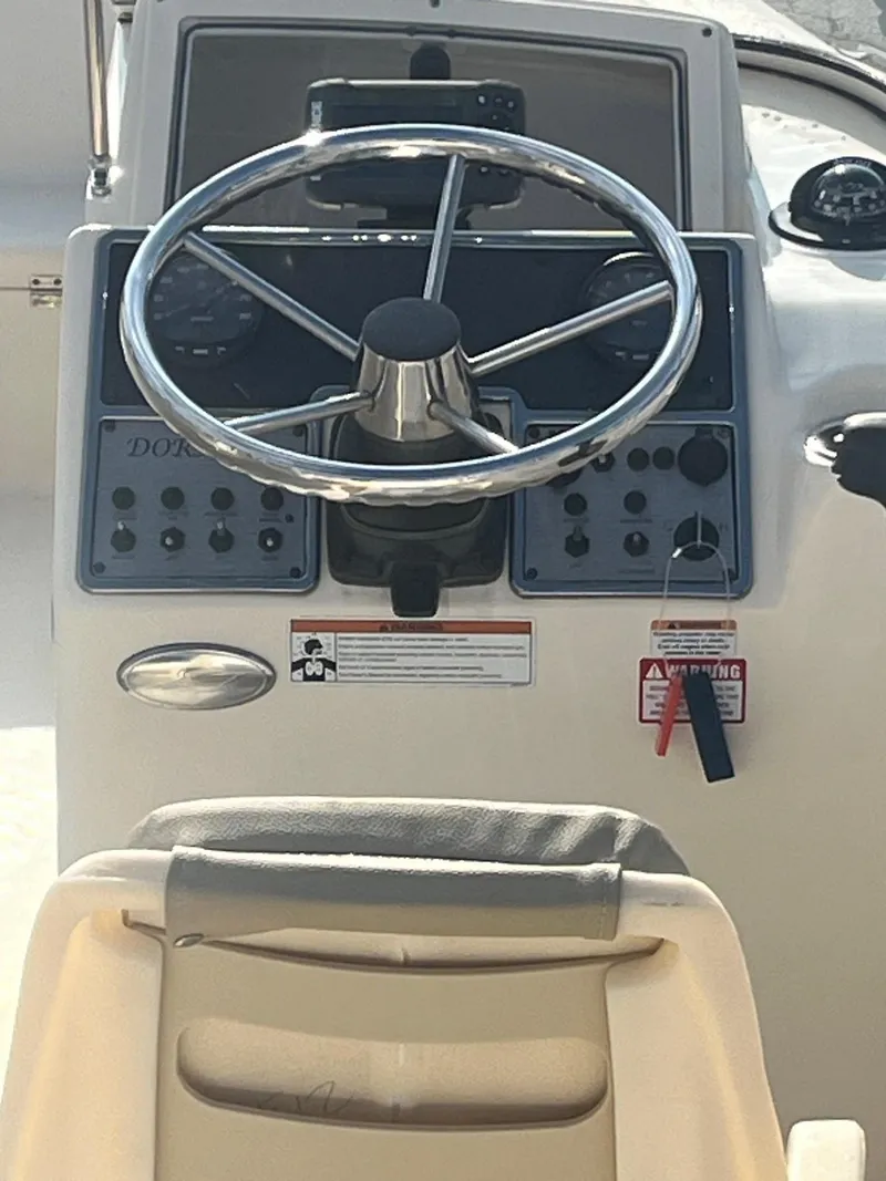 Slide: The Image of 2021 Scout 210 Dorado boat steering console with controls and gauges. - 6