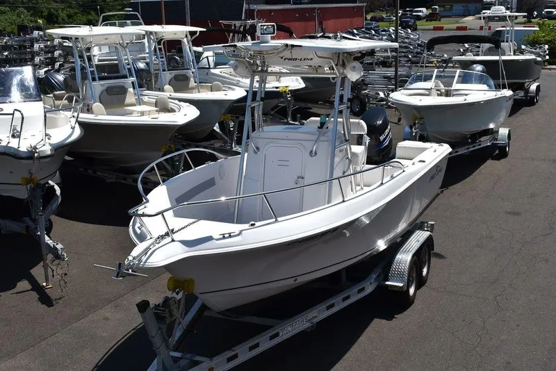 Slide: The Image of 2006 Pro-Line 21 Sport Center Console boat on trailer in a marina. - 3