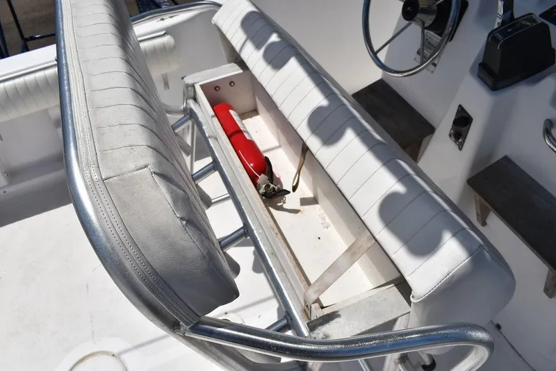 Slide: The Image of 2006 Pro-Line 21 Sport Center Console boat interior with storage compartment and fire extinguisher. - 33