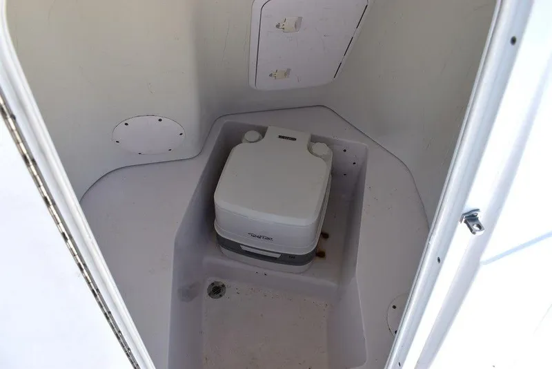 Slide: The Image of 2006 Pro-Line 21 Sport Center Console boat interior with portable toilet. - 48