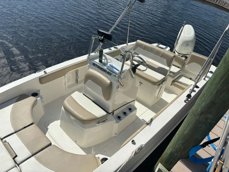 Slide: The Image of 2019 Stingray 186CC boat docked, featuring beige seating and a center console. - 7
