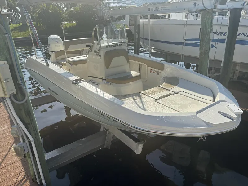 Slide: The Image of 2019 Stingray 186CC boat docked on a lift in a marina. - 9