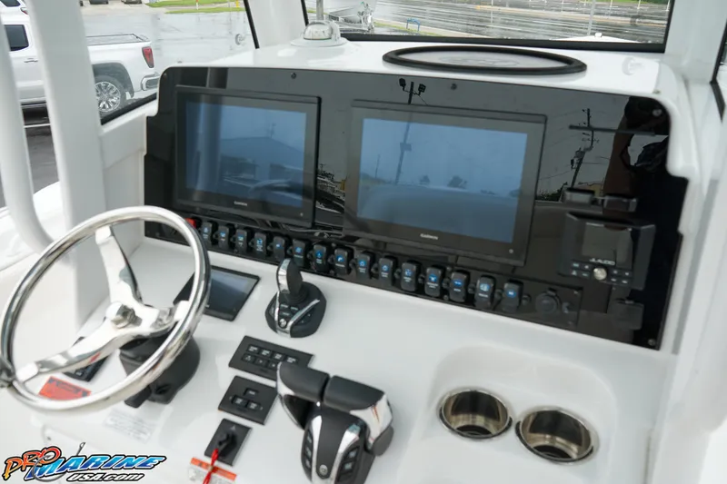Slide: The Image of 2023 Sea Hunt Ultra 275 SE boat dashboard with dual screens and controls. - 19