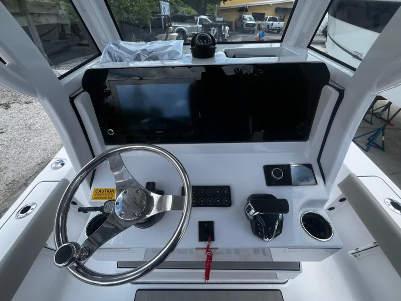 Slide: The Image of 2025 Sportsman Masters 227 Bay Boat helm with steering wheel and control panel. - 13