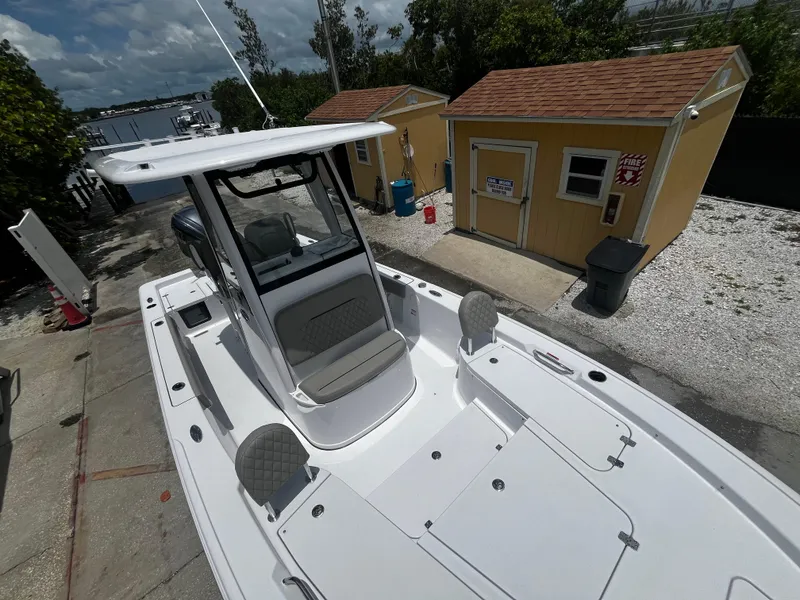 Slide: The Image of 2025 Sportsman Masters 227 Bay Boat docked near yellow cabins. - 22