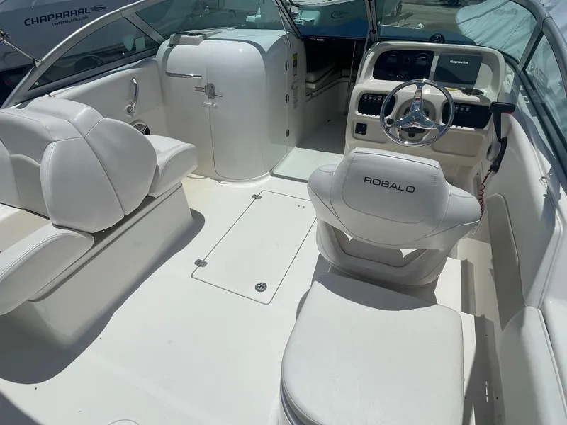 Slide: The Image of 2015 Robalo R227 Dual Console boat interior with white seating and steering console. - 3