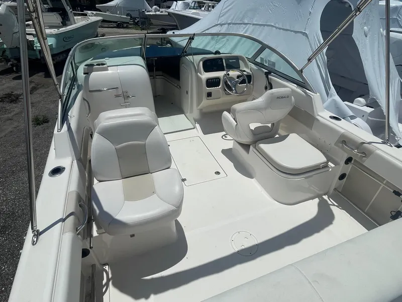 Slide: The Image of 2015 Robalo R227 Dual Console boat interior with white seating and steering console. - 4