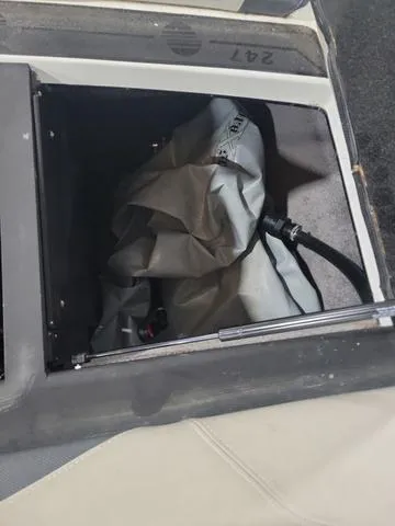Slide: The Image of 2015 Malibu 247 LSV storage compartment with equipment and hose. - 12