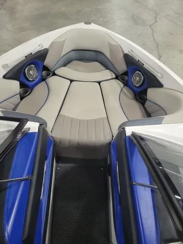 Slide: The Image of 2015 Malibu 247 LSV boat interior with blue accents and seating. - 9