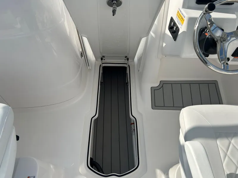 Slide: The Image of 2025 Sea Fox 228 Traveler boat interior with steering wheel and storage compartment. - 16