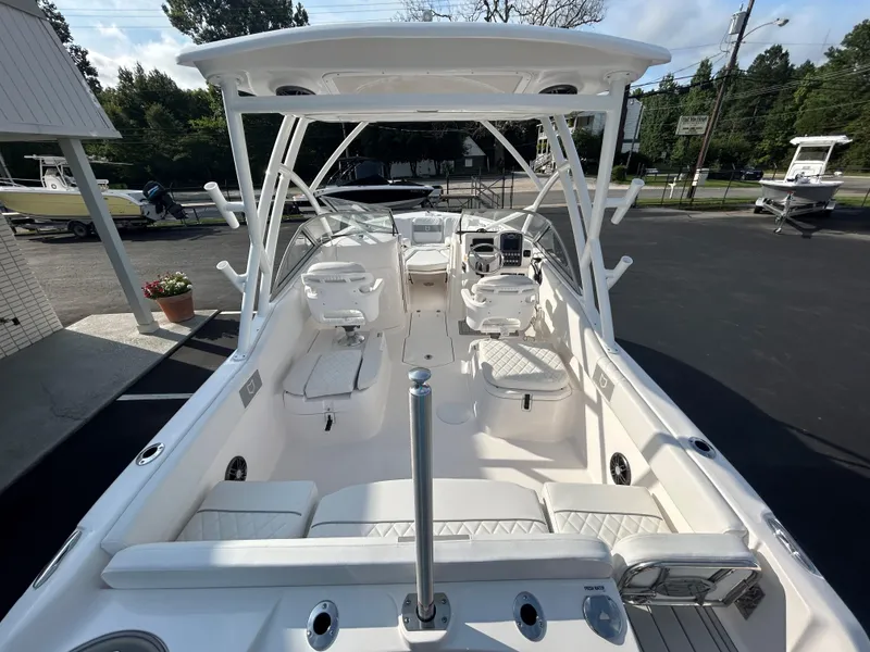 Slide: The Image of 2025 Sea Fox 228 Traveler boat interior with seating and helm, parked outdoors. - 19