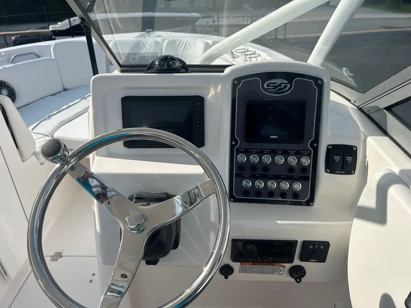 Slide: The Image of 2025 Sea Fox 228 Traveler boat dashboard with steering wheel and control panel. - 24