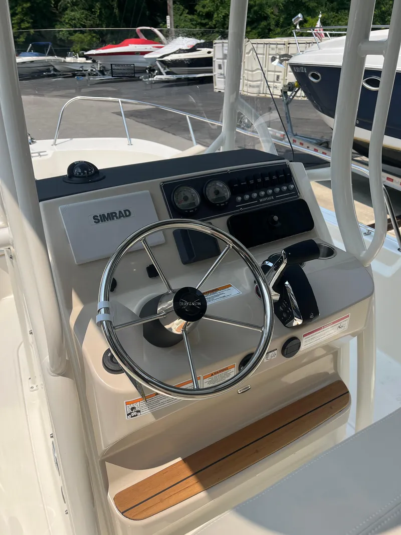 Slide: The Image of 2024 Boston Whaler 210 Montauk boat console with steering wheel and Simrad electronics. - 4