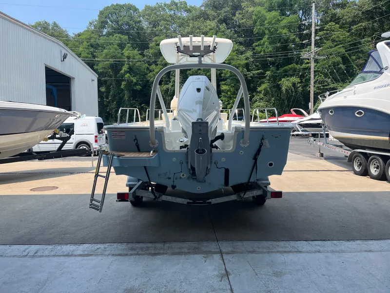Slide: The Image of 2024 Boston Whaler 210 Montauk boat on trailer, rear view, in a marina. - 7