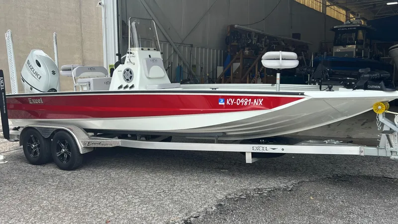 Slide: The Image of 2023 Excel 220 Bay Pro boat on trailer with Suzuki outboard motor. - 0