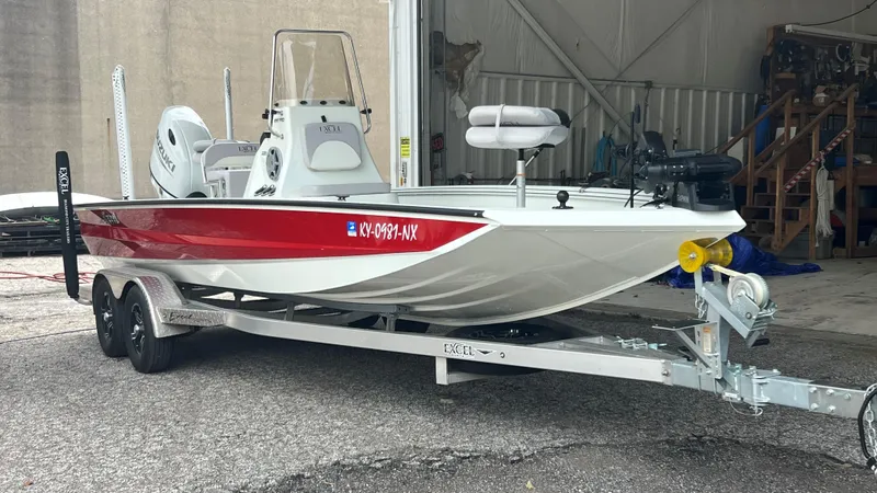 Slide: The Image of 2023 Excel 220 Bay Pro boat on trailer with Suzuki outboard motor. - 1