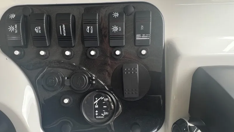 Slide: The Image of Control panel of 2023 Excel 220 Bay Pro boat with various switches and gauges. - 14