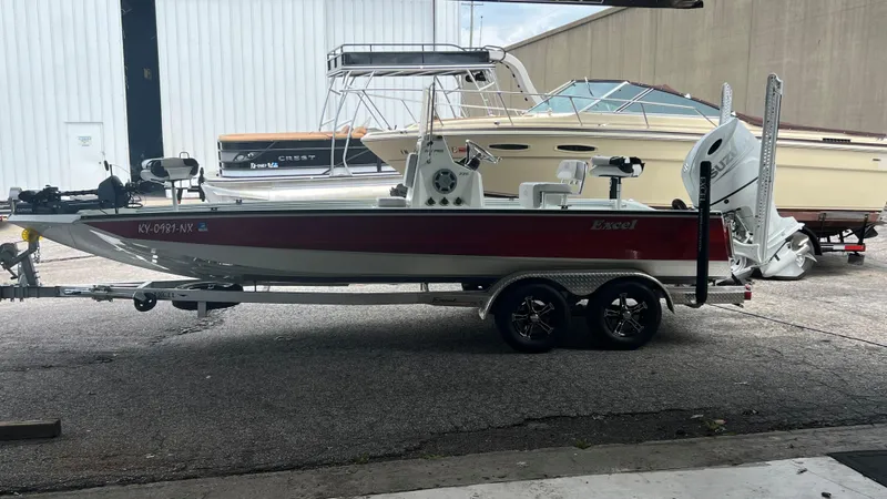 Slide: The Image of 2023 Excel 220 Bay Pro boat on trailer in storage facility. - 16