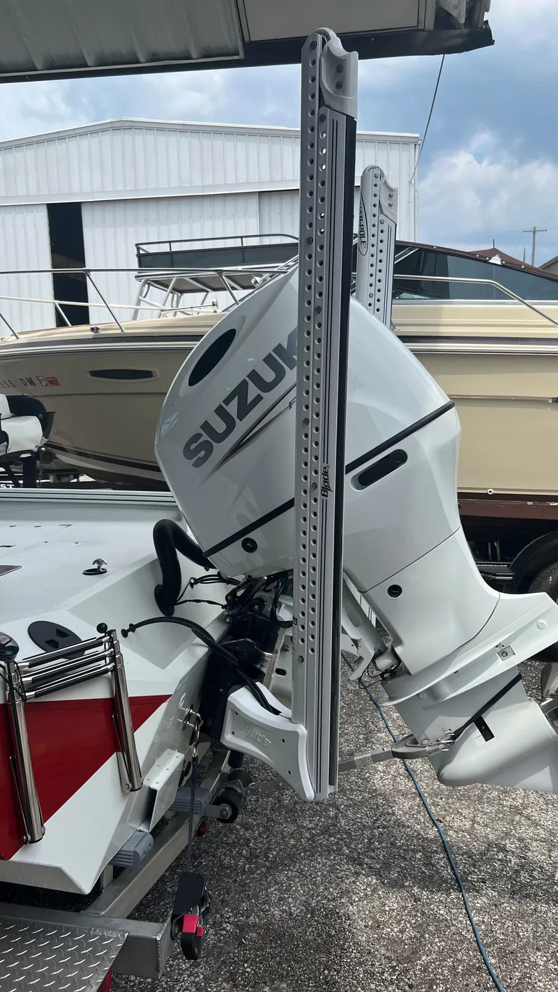 Slide: The Image of 2023 Excel 220 Bay Pro boat with Suzuki outboard motor in a marina. - 18