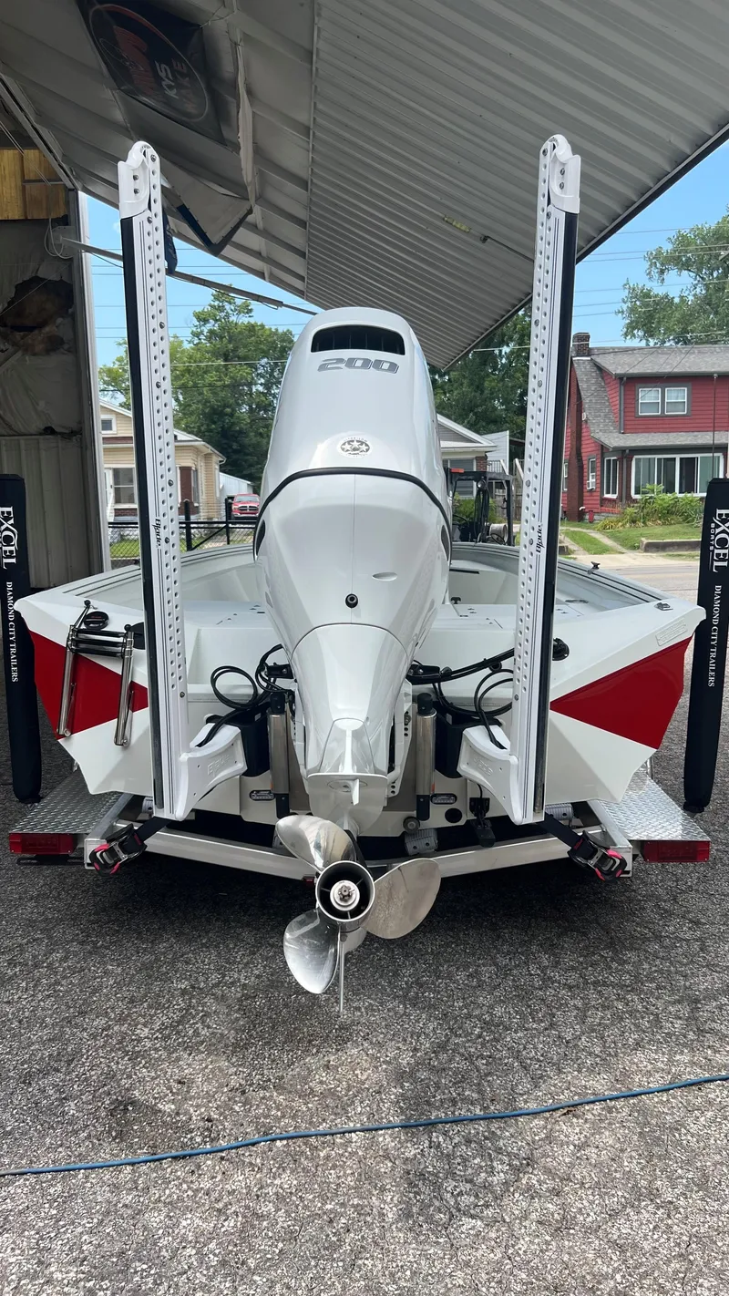 Slide: The Image of 2023 Excel 220 Bay Pro boat with powerful outboard motor and trailer. - 19