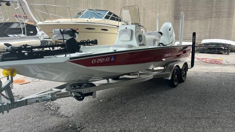Slide: The Image of 2023 Excel 220 Bay Pro boat on trailer, equipped with Garmin electronics. - 2