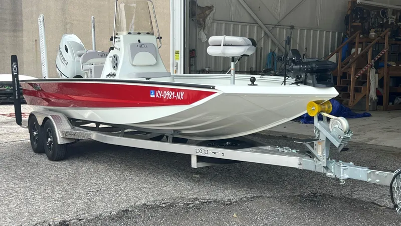 Slide: The Image of 2023 Excel 220 Bay Pro boat on trailer, red and white, Suzuki outboard motor. - 3