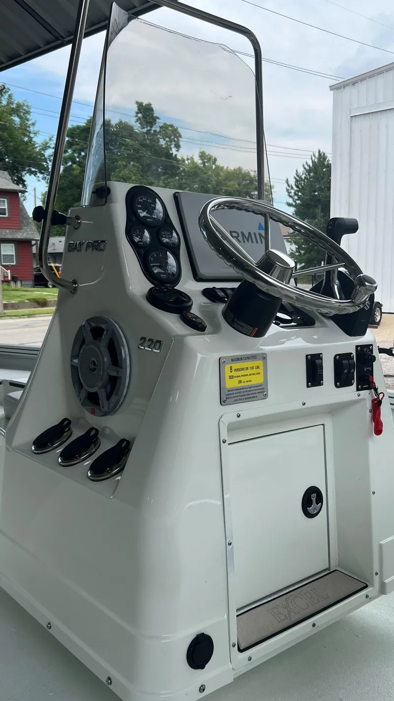 Slide: The Image of 2023 Excel 220 Bay Pro boat console with steering wheel and gauges. - 4