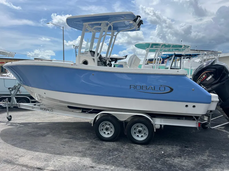 Slide: The Image of 2024 Robalo R230 Center Console boat on a trailer, side view. - 1
