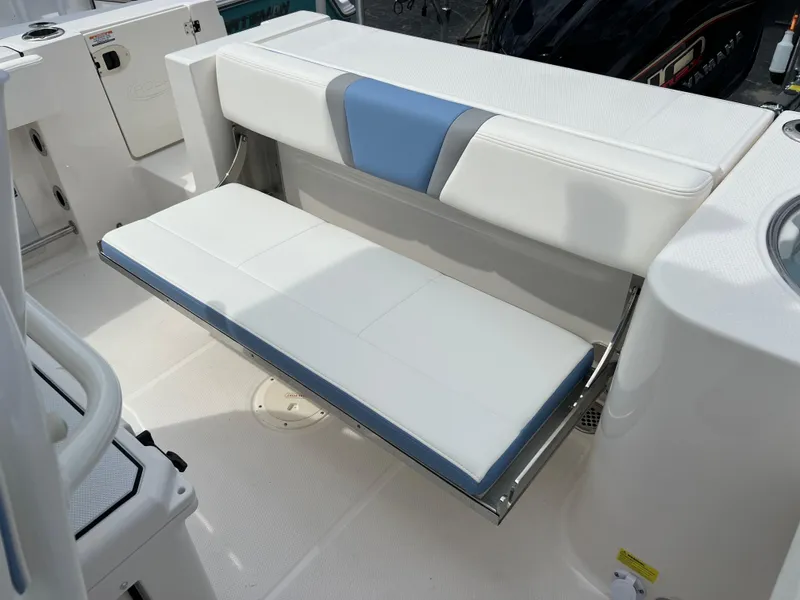 Slide: The Image of 2024 Robalo R230 Center Console boat with white and blue cushioned seating. - 12