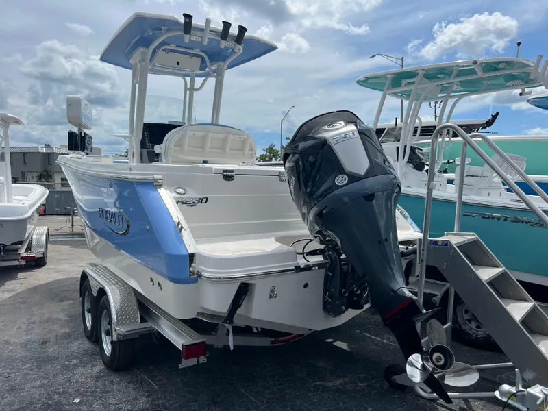 Slide: The Image of 2024 Robalo R230 Center Console boat with outboard motor on trailer. - 2