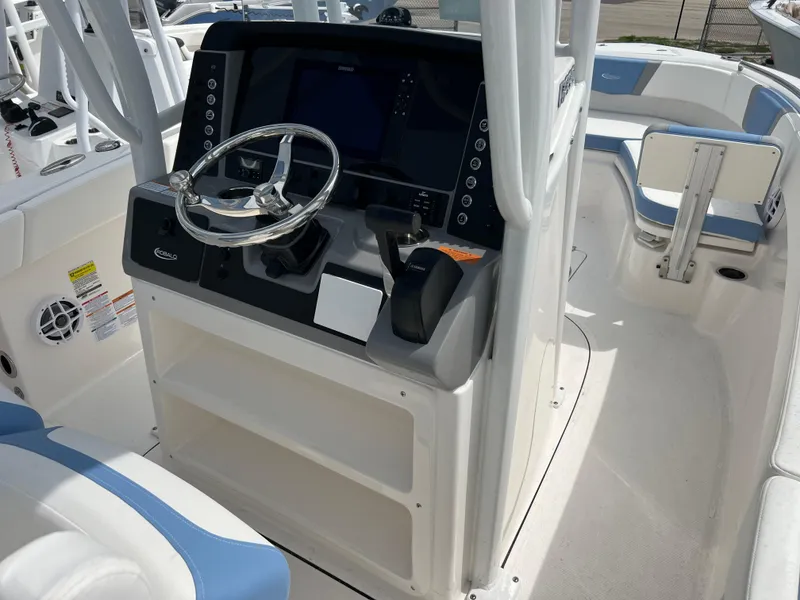 Slide: The Image of 2024 Robalo R230 Center Console boat interior with steering wheel and control panel. - 5