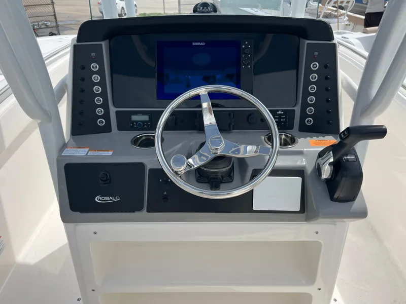 Slide: The Image of 2024 Robalo R230 Center Console boat helm with steering wheel and control panel. - 6
